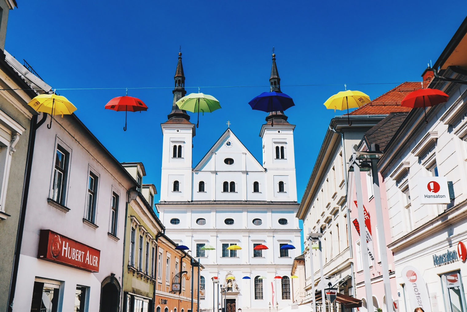 Regenschirme in der Timmersdorfergasse mit Stadtpfarrkirche im Hintergrund